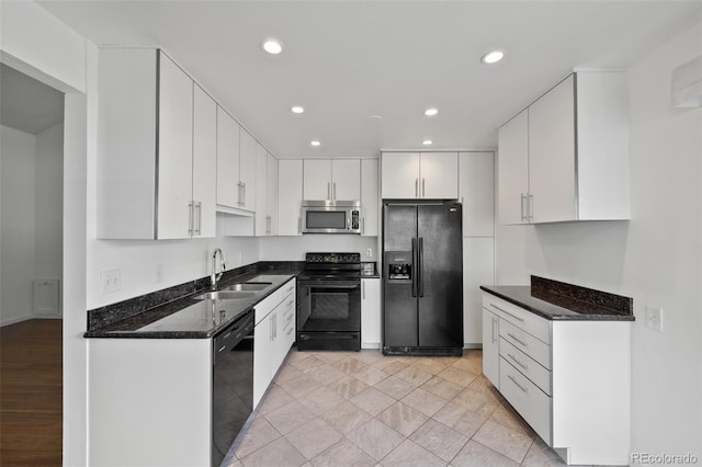 kitchen featuring a sink, white cabinets, black appliances, dark stone countertops, and recessed lighting