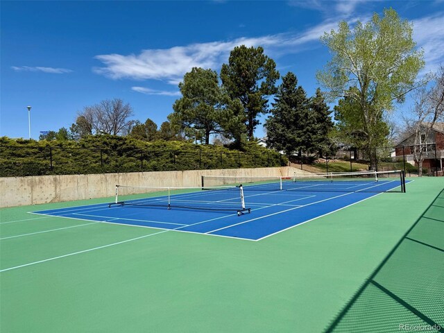 view of tennis court featuring fence and community basketball court