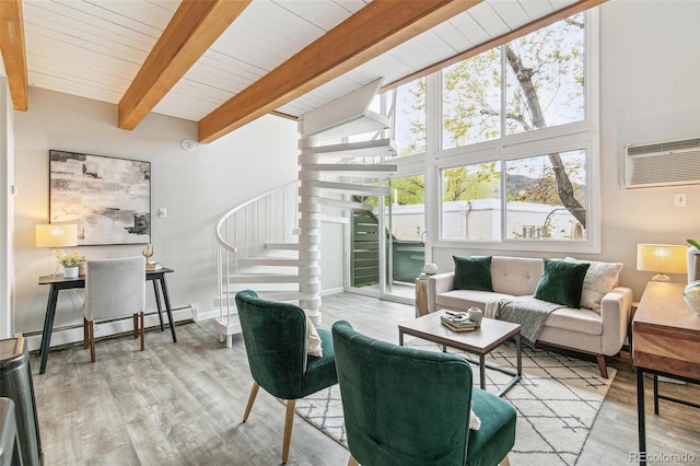 living room featuring a wall mounted air conditioner, wood finished floors, baseboard heating, and stairway