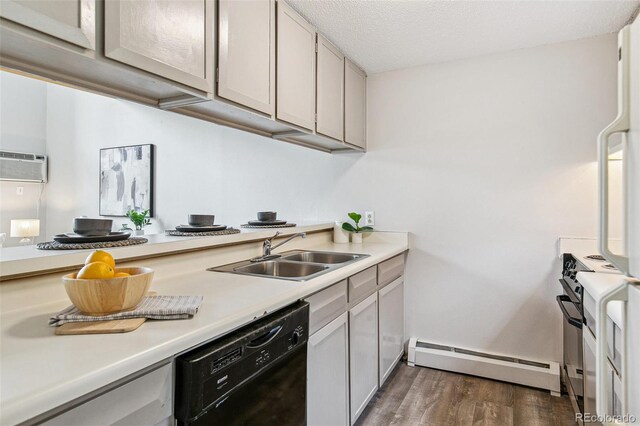 kitchen featuring wood finished floors, black dishwasher, baseboard heating, light countertops, and a sink