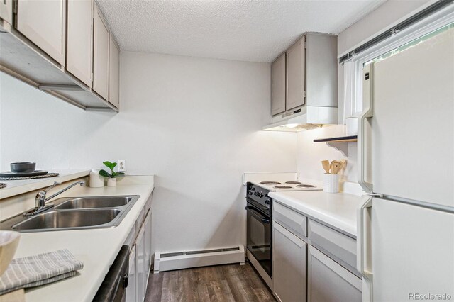kitchen with black / electric stove, a sink, a baseboard radiator, freestanding refrigerator, and under cabinet range hood