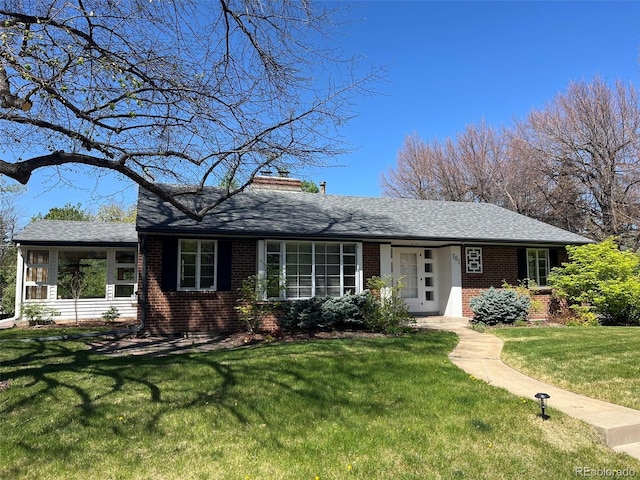 701 S Clayton St, Denver, CO 80209 - view of front of home with brick siding, a front lawn, a chimney, and roof with shingles