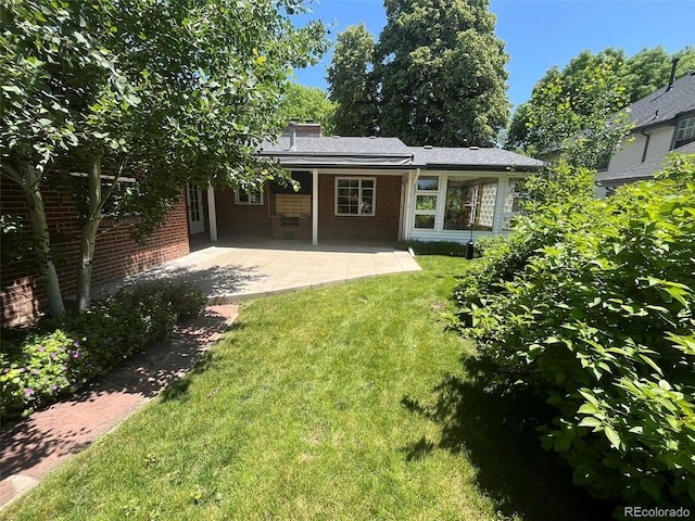 701 S Clayton St, Denver, CO 80209 - rear view of house featuring a yard, brick siding, a patio area, and a chimney