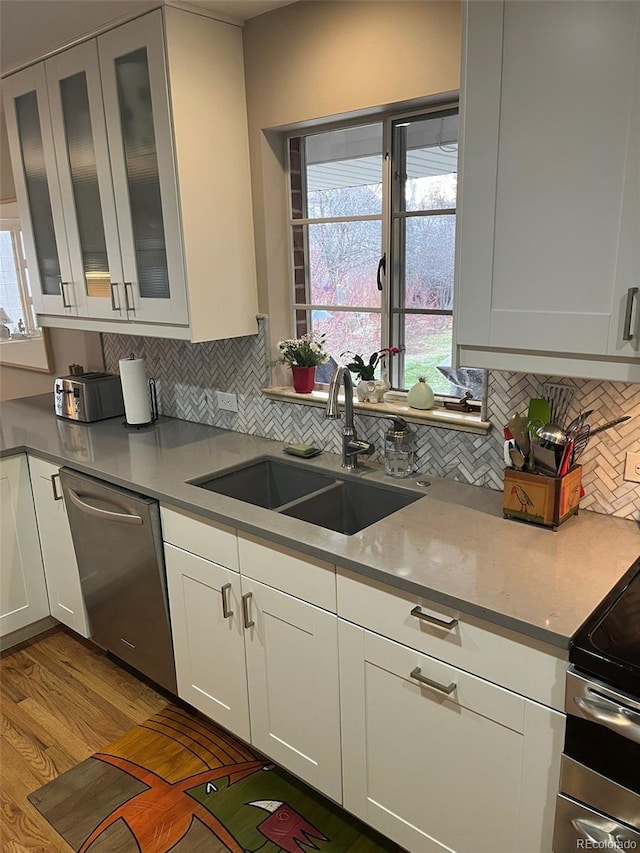 701 S Clayton St, Denver, CO 80209 - kitchen with appliances with stainless steel finishes, tasteful backsplash, white cabinets, and glass insert cabinets