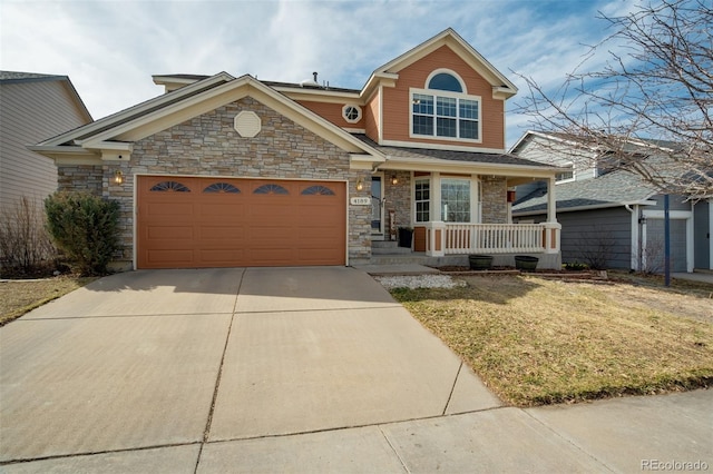 view of front of property with stone siding, a porch, an attached garage, and driveway