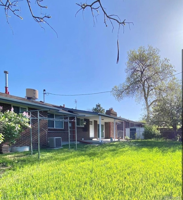 13024 E Alaska Pl, Aurora, CO 80012 - back of house with a patio, brick siding, and a chimney