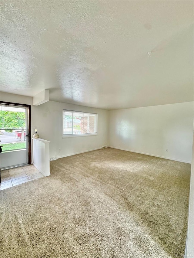 13024 E Alaska Pl, Aurora, CO 80012 - unfurnished living room featuring light carpet, a textured ceiling, and healthy amount of natural light