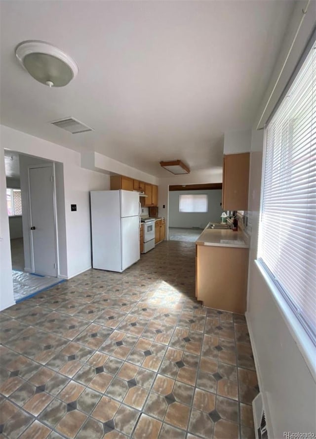 13024 E Alaska Pl, Aurora, CO 80012 - kitchen featuring white appliances and brown cabinetry