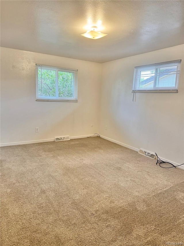 13024 E Alaska Pl, Aurora, CO 80012 - carpeted empty room with healthy amount of natural light and a textured ceiling