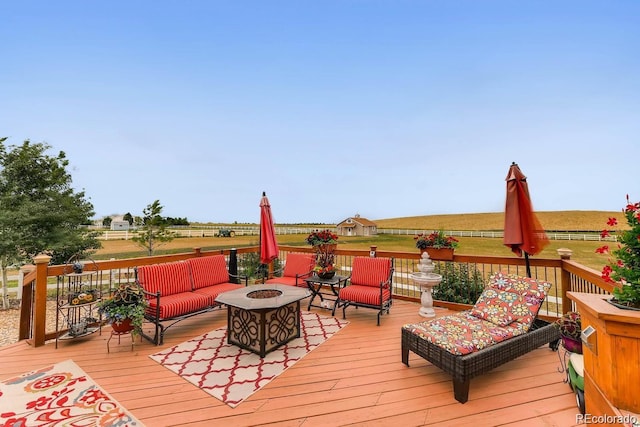 wooden deck with a rural view and an outdoor fire pit