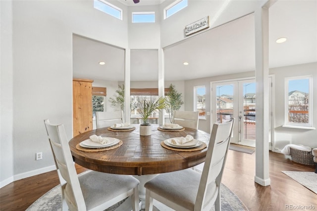 dining area with a high ceiling, dark hardwood / wood-style floors, and french doors