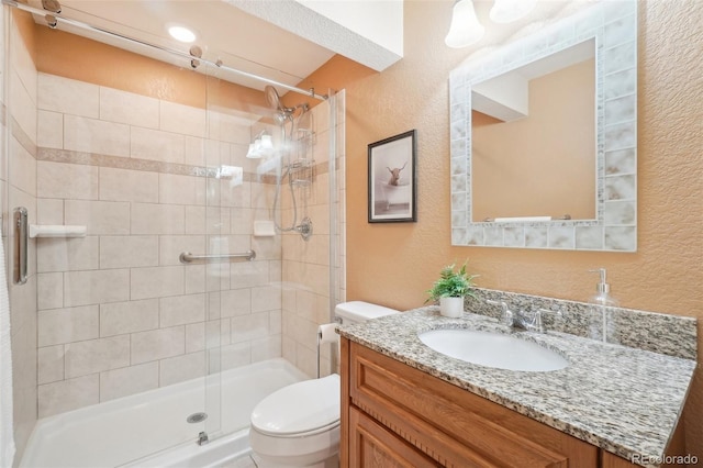 bathroom featuring vanity, toilet, and an enclosed shower