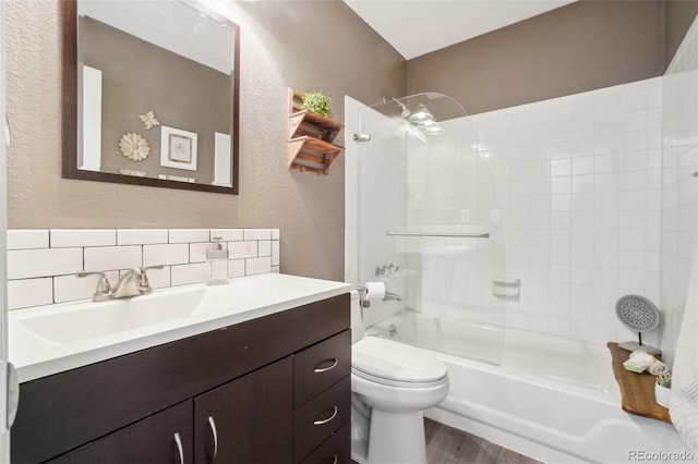 full bathroom with vanity, hardwood / wood-style floors, toilet, and tiled shower / bath