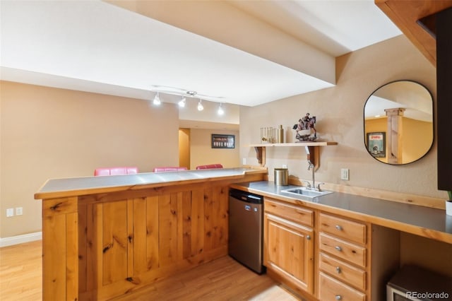 kitchen featuring sink, track lighting, dishwasher, kitchen peninsula, and light hardwood / wood-style floors