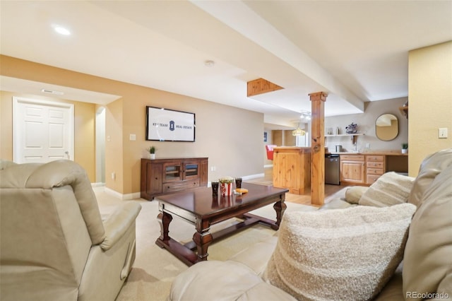 carpeted living room with bar area and ornate columns