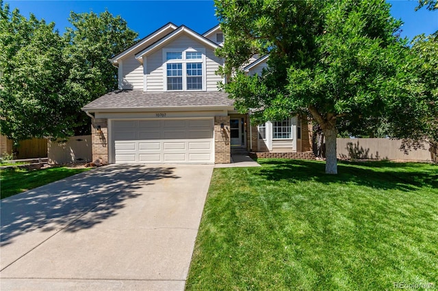 view of front of house featuring driveway, brick siding, a front yard, and fence