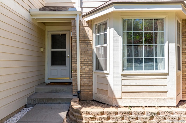 view of exterior entry featuring brick siding