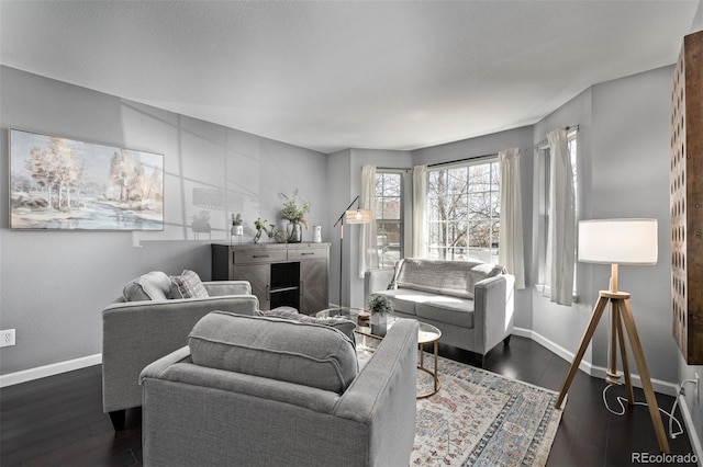 living area featuring dark wood-style flooring and baseboards