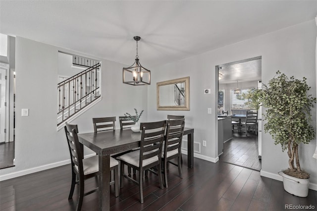 dining room with dark wood-style floors, stairway, baseboards, and a notable chandelier