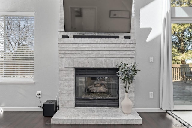 interior details with a fireplace, baseboards, and wood finished floors