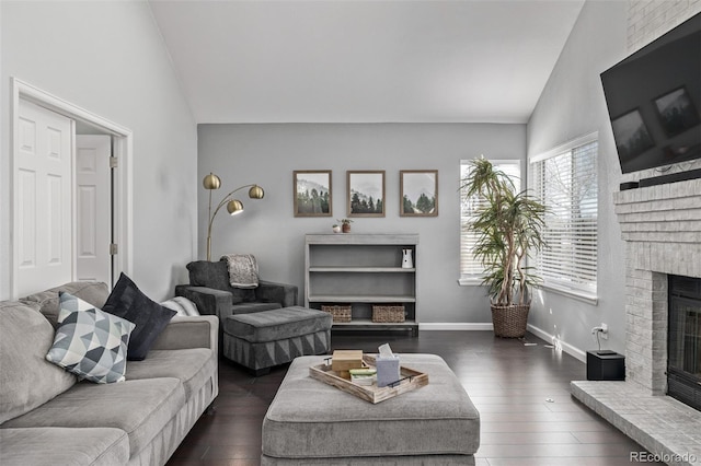 living room with vaulted ceiling, dark wood-style flooring, and a fireplace