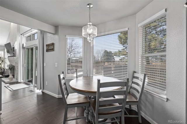 dining area with a chandelier, dark wood finished floors, and baseboards