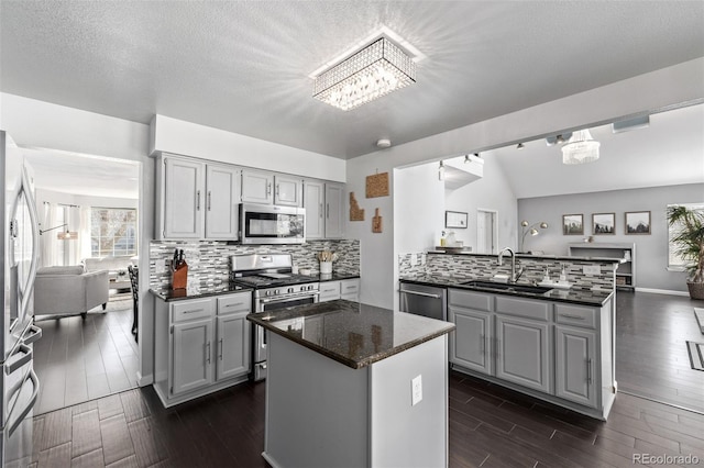 kitchen featuring appliances with stainless steel finishes, gray cabinets, and a notable chandelier