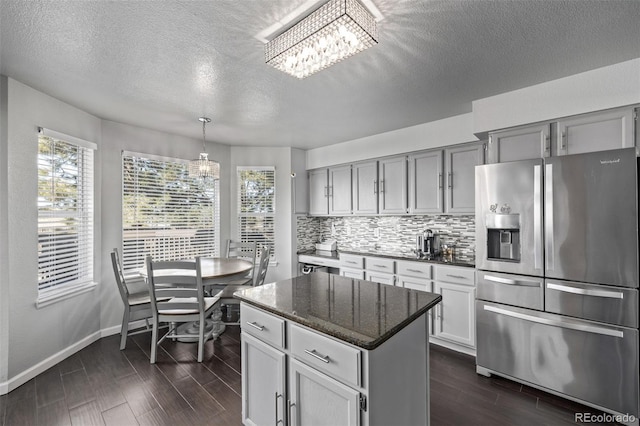 kitchen featuring a notable chandelier, tasteful backsplash, wood tiled floor, and stainless steel fridge with ice dispenser