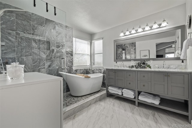 full bathroom featuring marble finish floor, tile walls, a sink, a textured ceiling, and tiled shower