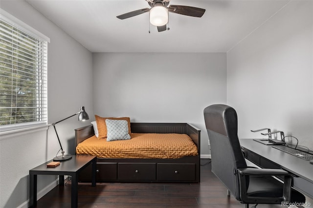 bedroom with baseboards, multiple windows, a ceiling fan, and wood finished floors