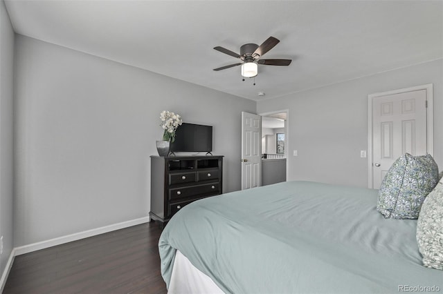 bedroom with dark wood-style floors, a ceiling fan, and baseboards