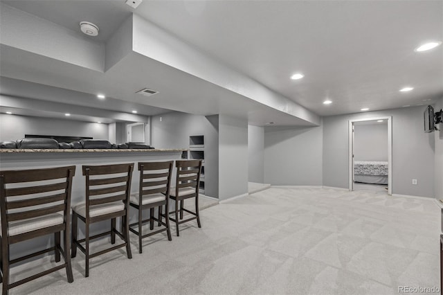 bar with light carpet, baseboards, visible vents, a bar, and recessed lighting