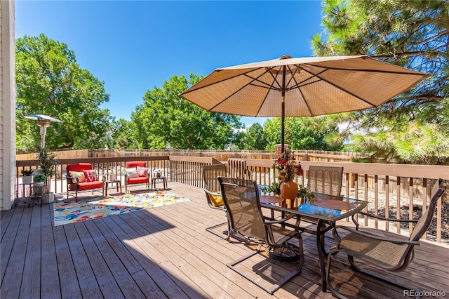 deck featuring a fenced backyard and outdoor dining area