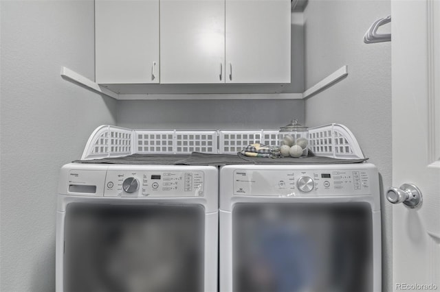 laundry area with independent washer and dryer and cabinet space