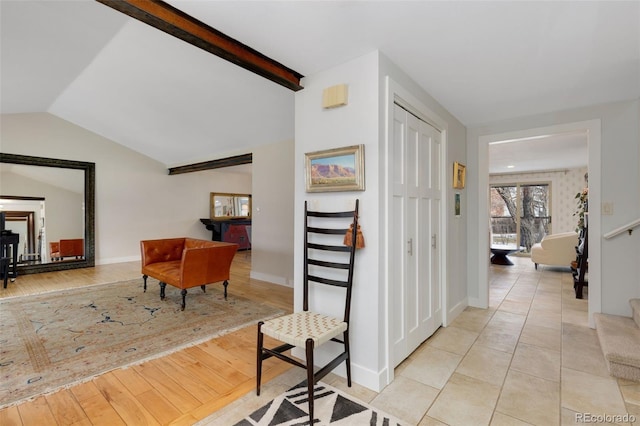 hall with light hardwood / wood-style floors and lofted ceiling with beams