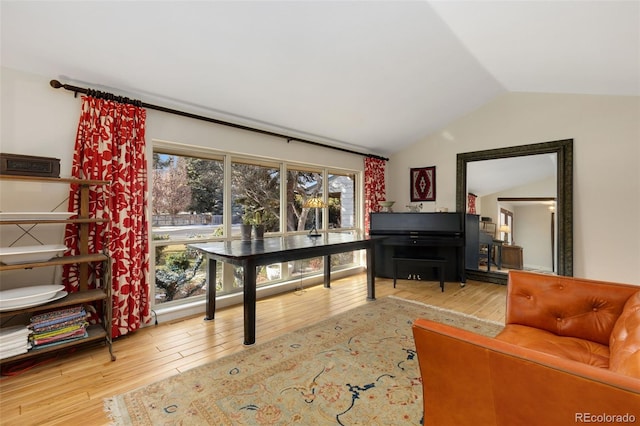 living room featuring lofted ceiling and hardwood / wood-style flooring