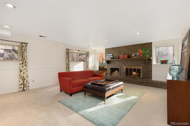 carpeted living room featuring a healthy amount of sunlight and a brick fireplace