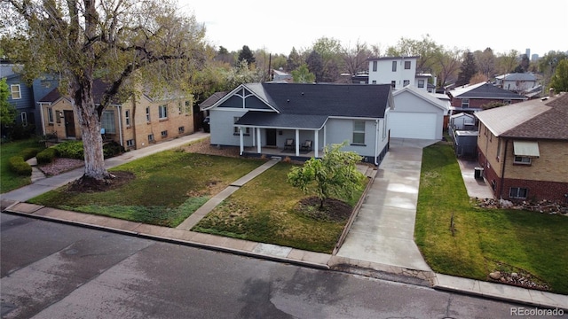 view of front facade with a residential view, roof with shingles, a front yard, covered porch, and driveway