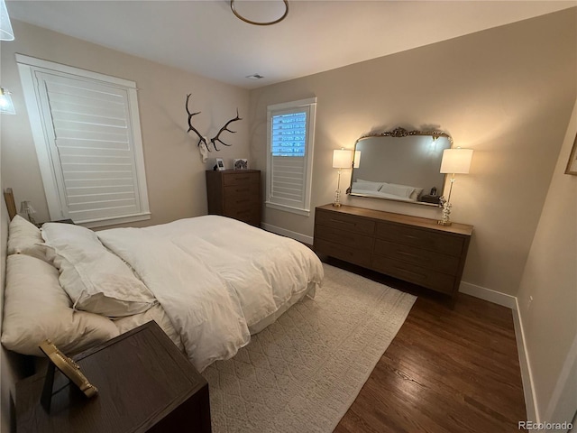 bedroom with baseboards and dark wood finished floors