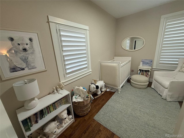 bedroom with wood finished floors and multiple windows