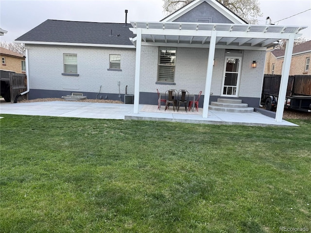 rear view of house with fence, a yard, a patio area, and brick siding