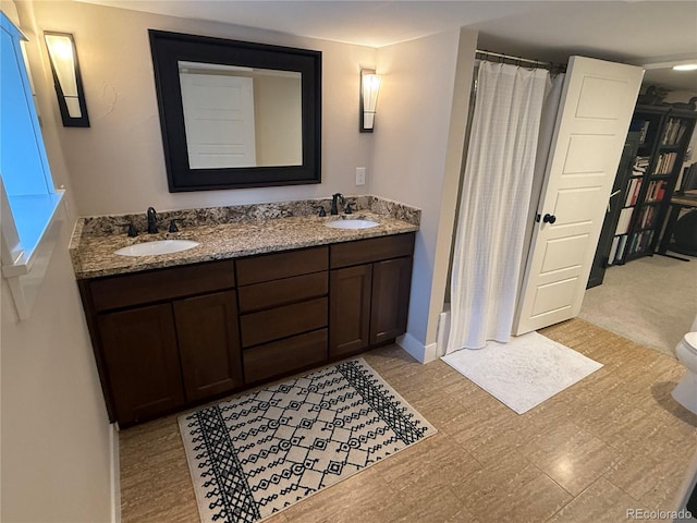full bath with double vanity, a sink, and a shower with shower curtain