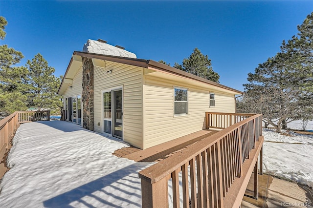 snow covered house featuring a wooden deck