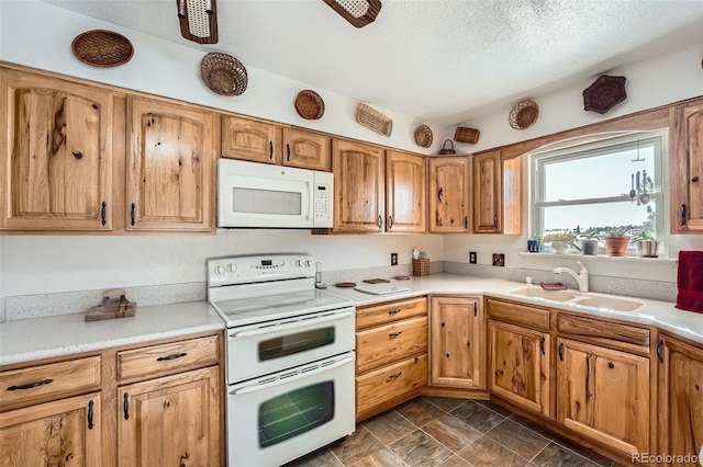 kitchen with a textured ceiling, sink, and white appliances