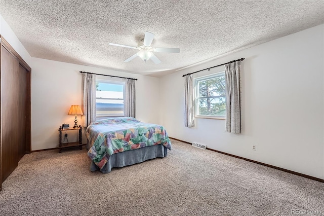 bedroom with carpet, ceiling fan, and multiple windows