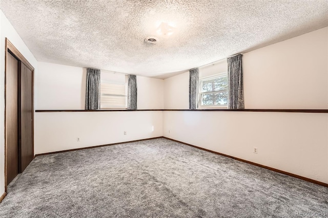 unfurnished bedroom with a closet, carpet floors, and a textured ceiling