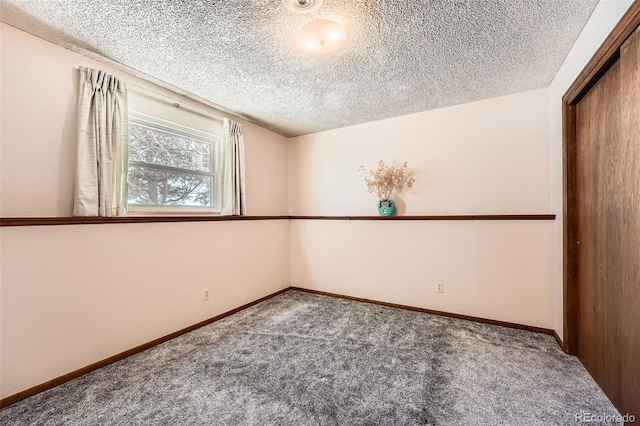 carpeted spare room with a textured ceiling