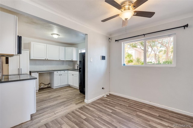 kitchen with white cabinetry, decorative backsplash, ceiling fan, black refrigerator with ice dispenser, and light hardwood / wood-style flooring