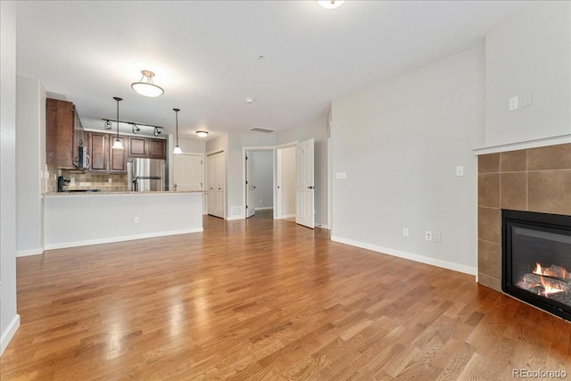 unfurnished living room with light hardwood / wood-style flooring and a fireplace