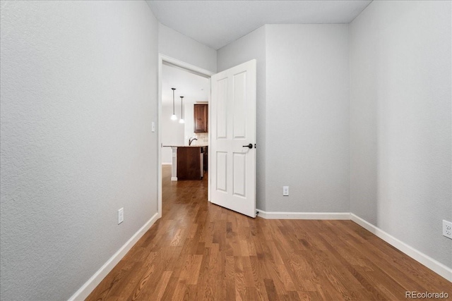 corridor with sink and wood-type flooring